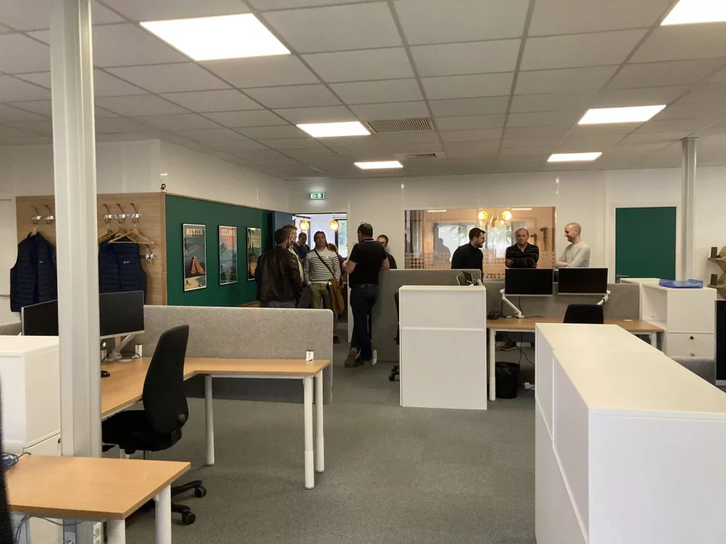 Bureau moderne avec groupes de personnes en discussion.