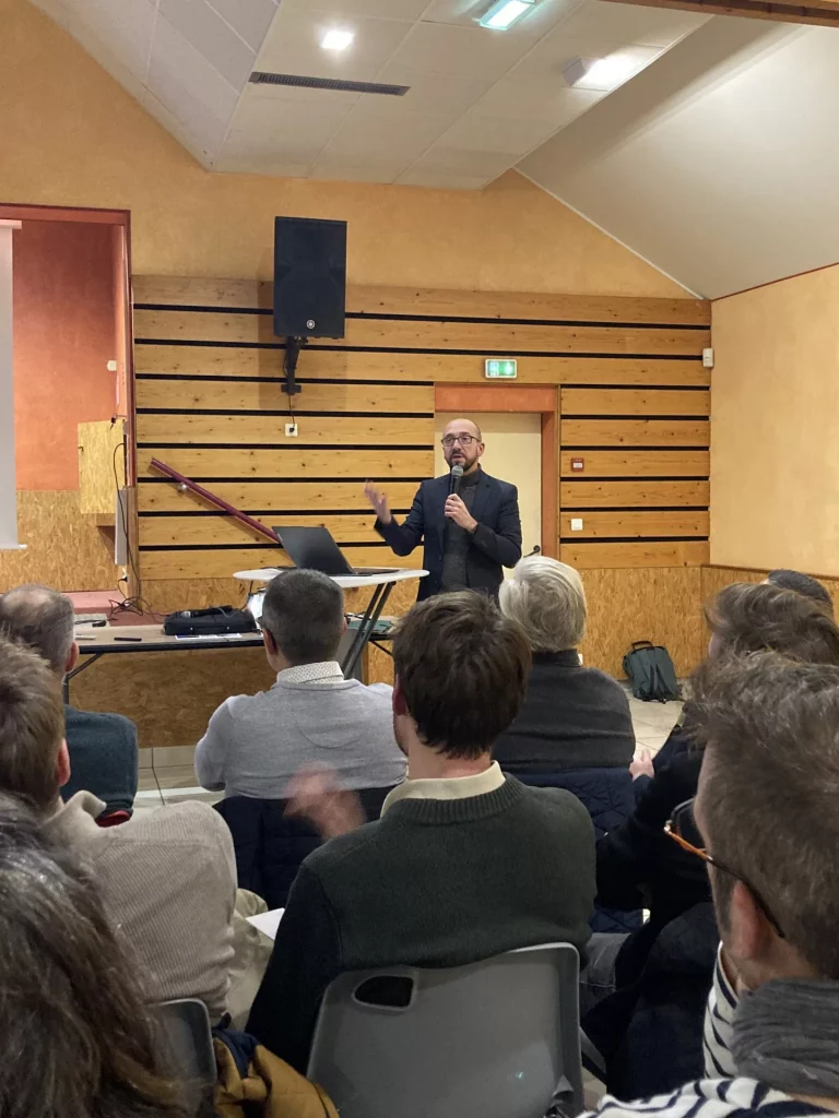 Conférencier Emmanuel Derrien devant un public attentif.
