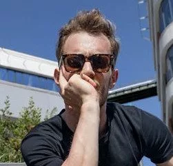 Homme avec des lunettes de soleil, en pleine réflexion.