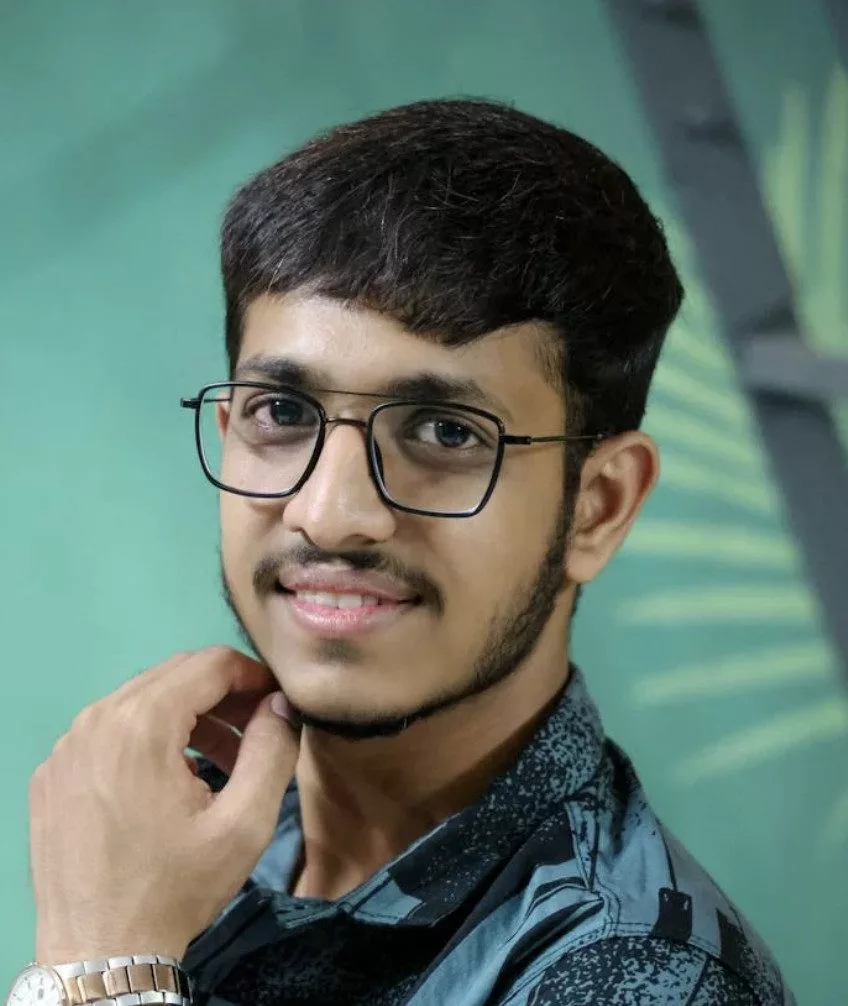 Jeune homme souriant avec des lunettes.