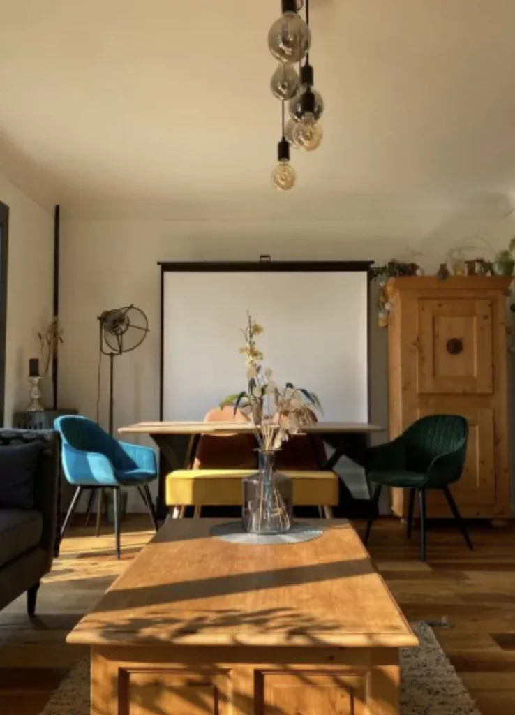 Intérieur lumineux avec table, chaises et décoration.