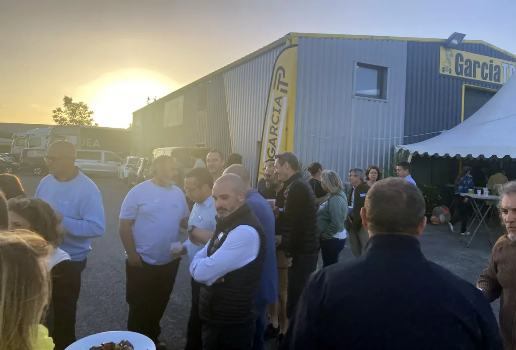Rassemblement devant bâtiment industriel au coucher du soleil