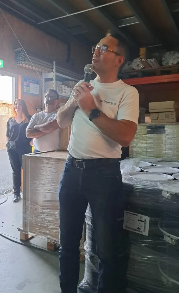 Homme parlant au micro dans un entrepôt